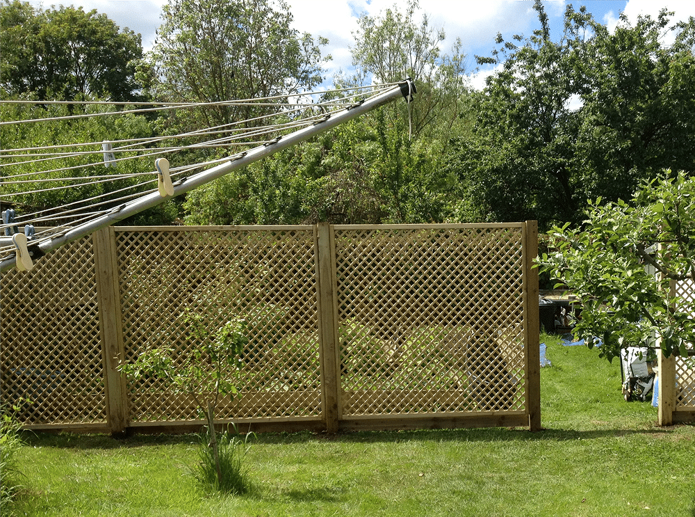Clothesline in a garden beside a lattice fence and trees